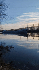 Woman takes riverside selfies as barge passes in Chaikovsky
