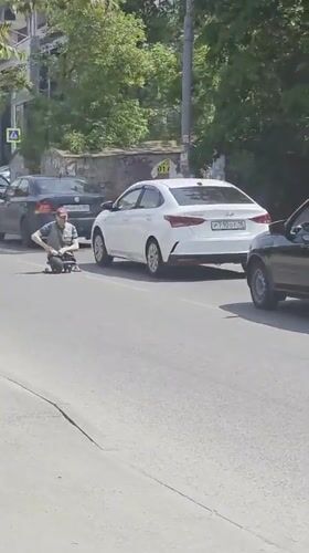 Man skateboards through Krasnodar streets near justice sculpture