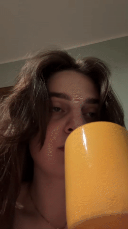 Person drinks from Thailand mug in Bratislava home