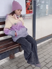 Young person with lollipop waits at Novosibirsk bus stop