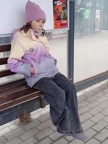 Young person with lollipop waits at Novosibirsk bus stop