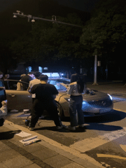 Group gathers around illuminated sedan in Nan'an District