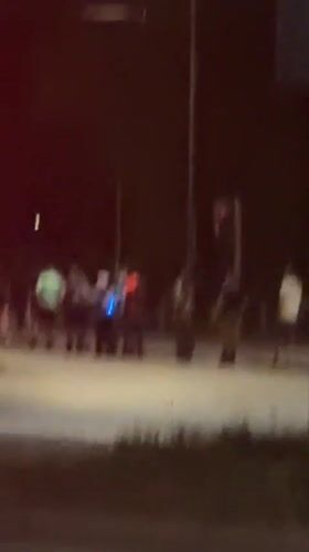 Dozen people gather, converse at Milan intersection at night