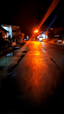 Palestinian flag flies over illuminated Lhokseumawe building at night