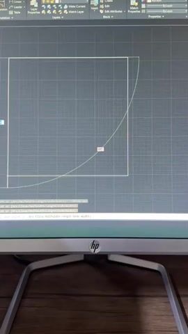 This is a screen recording of someone using CAD software on a computer, likely for design or drafting. The primary subject is the computer monitor displaying the CAD interface. The scene is an interior setting, likely a home or office, given the wooden desk surface visible beneath the monitor and the HP logo on the monitor stand.

The CAD software shows a grid background with a square shape being drawn, and a curved line, possibly an arc, originating from one corner and extending outwards. A small label displaying "90°" is visible near the arc, indicating an angle measurement. The command line at the bottom of the screen shows text related to drawing commands, such as "next point or [Arc Close Halfwidth Length Undo Width]". The user appears to be in the process of creating or modifying a design. There is no indication of people or specific time of day or weather. The location context of Turkmenkishlak, Uzbekistan is not discernible from the visual information presented in the image itself.