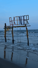 Woman takes beach selfies near playground in Mata de Uva