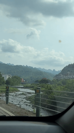 Vehicle captures scenic river view while driving through Wulingyuan