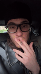 Young man smoking cigarette in car in Gif-sur-Yvette