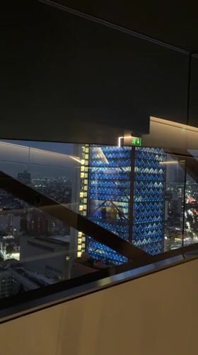 Mexico City's blue-lit skyscraper at night, multiple angles