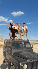 Young adults pose on SUV roof in Göreme Turkey