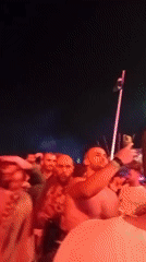 Nighttime festival crowd, colored lights, selfies in the mix