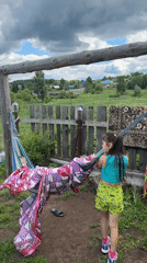 Children play in backyard hammock as storm clouds gather