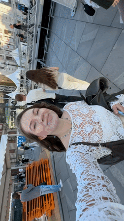 Woman Takes Selfie in Belgrade While Passerby Walks Behind