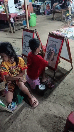 Kids paint cartoon characters at a night market art stall