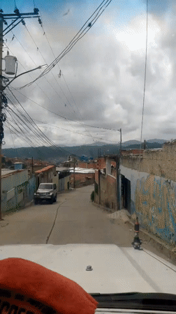Street-level and balcony views across a Caracas hillside neighborhood