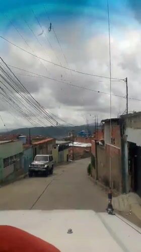 Street-level and balcony views across a Caracas hillside neighborhood