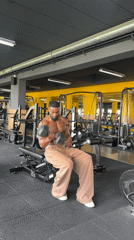 Tattooed man performs bicep curls at Paris gym