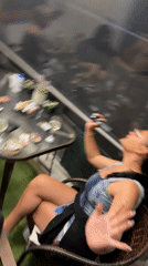 Social gathering observed around cluttered patio table in Nea Peramos