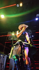 Cowboy-hatted cyclist performs on illuminated stage in Puebla