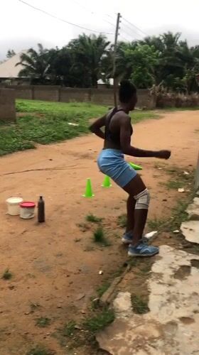 Woman conducts morning exercise routine in Akwanga dirt yard