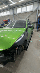 Green BMW M4 undergoes modifications in auto workshop