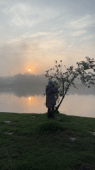 Woman photographs sunrise lake scene in Da Lat, Vietnam