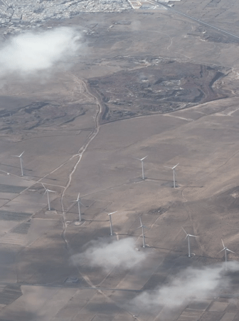 Wind farm spotted across barren landscape near Teguise, Spain