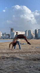 Young men perform beach acrobatics in Tangier, Morocco