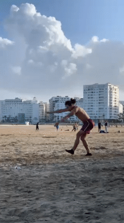 Young men perform beach acrobatics in Tangier, Morocco