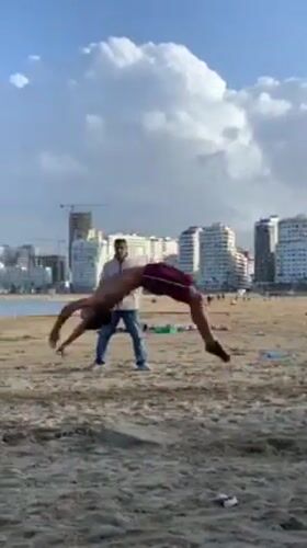 Young men perform beach acrobatics in Tangier, Morocco