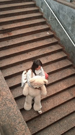 Marble staircase pause with a oversized teddy bear in hand