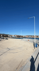 People gather at sunny Greek harbor on spring afternoon
