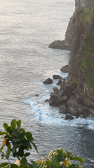 Ocean waves crash against rocky cliffs in Kuta Selatan