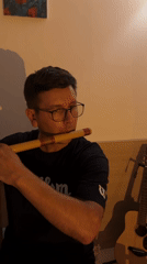 Man plays flute and guitar in indoor music session