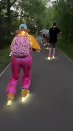Group rollerblades with glowing skates in Krasnoyarsk park at dusk