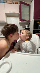 Children share tender moment in Russian kitchen