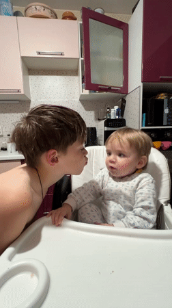 Children share tender moment in Russian kitchen