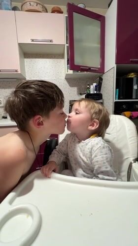 Children share tender moment in Russian kitchen