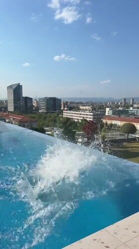 Rooftop pool and pink plane over Sofia on a clear afternoon