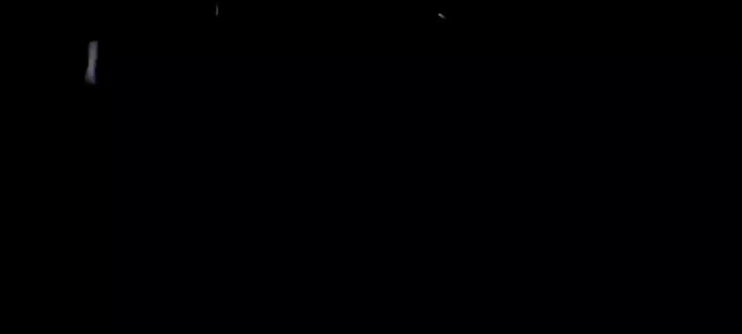 The video shows rain falling, captured on a dark background. The rain streaks are illuminated against the black, making them visible.