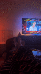 Late-night TV viewing with feline companionship in Belgrade bedroom