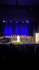 Choir performs under blue lights in Calella concert hall