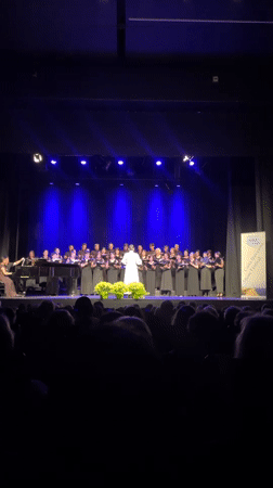 Choir performs under blue lights in Calella concert hall