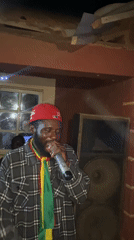 Nighttime community celebration with music and Ghanaian flags in Nigeria