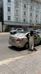 Woman enters gold Toyota sedan in Đà Nẵng morning