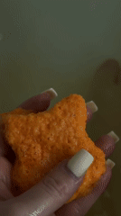 Person drops orange bear bath bomb into bathtub