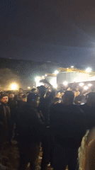 Nighttime crowd gathers with phones in Safi, Morocco