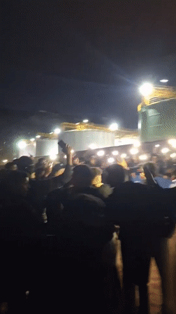 Nighttime crowd gathers with phones in Safi, Morocco