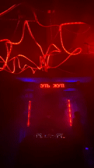 Nightclub with Russian signage hosts DJ set, patrons gather