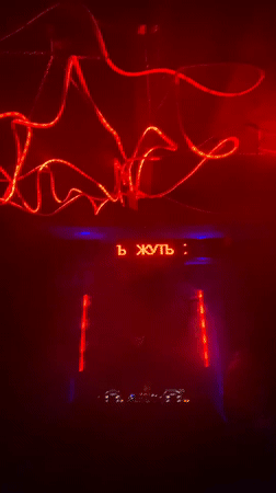 Nightclub with Russian signage hosts DJ set, patrons gather